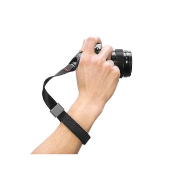 Photographer’s hand holding a camera secured with the Peak Design Cuff black wrist strap