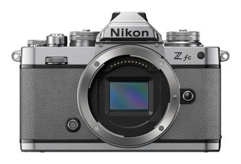 Front view of Nikon Z fc mirrorless camera body in grey, showing DX-format sensor and retro-style controls.