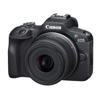 Angled front view of Canon EOS R100 with RF-S 18-45mm f/4.5-6.3 IS STM lens