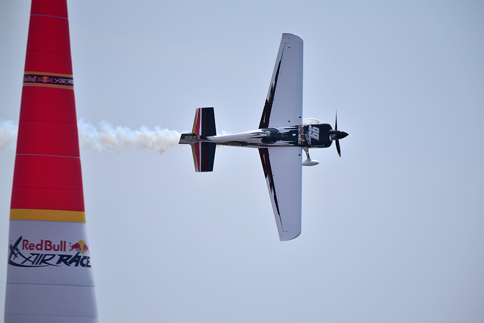 Plane flying on its side around an obstacle at the Red Bull Air Race, photographed with the