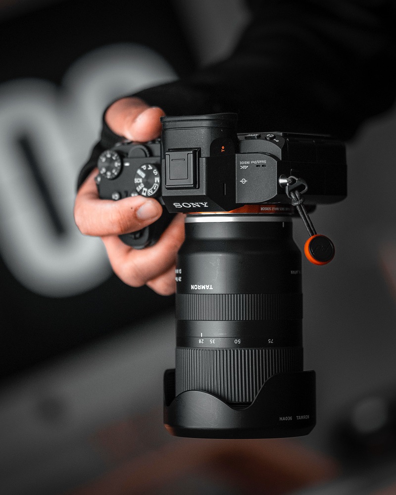 man holding a sony mirrorless camera